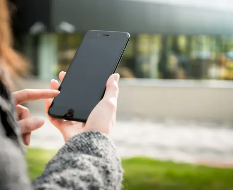 A woman on her mobile phone outdoors making a call.